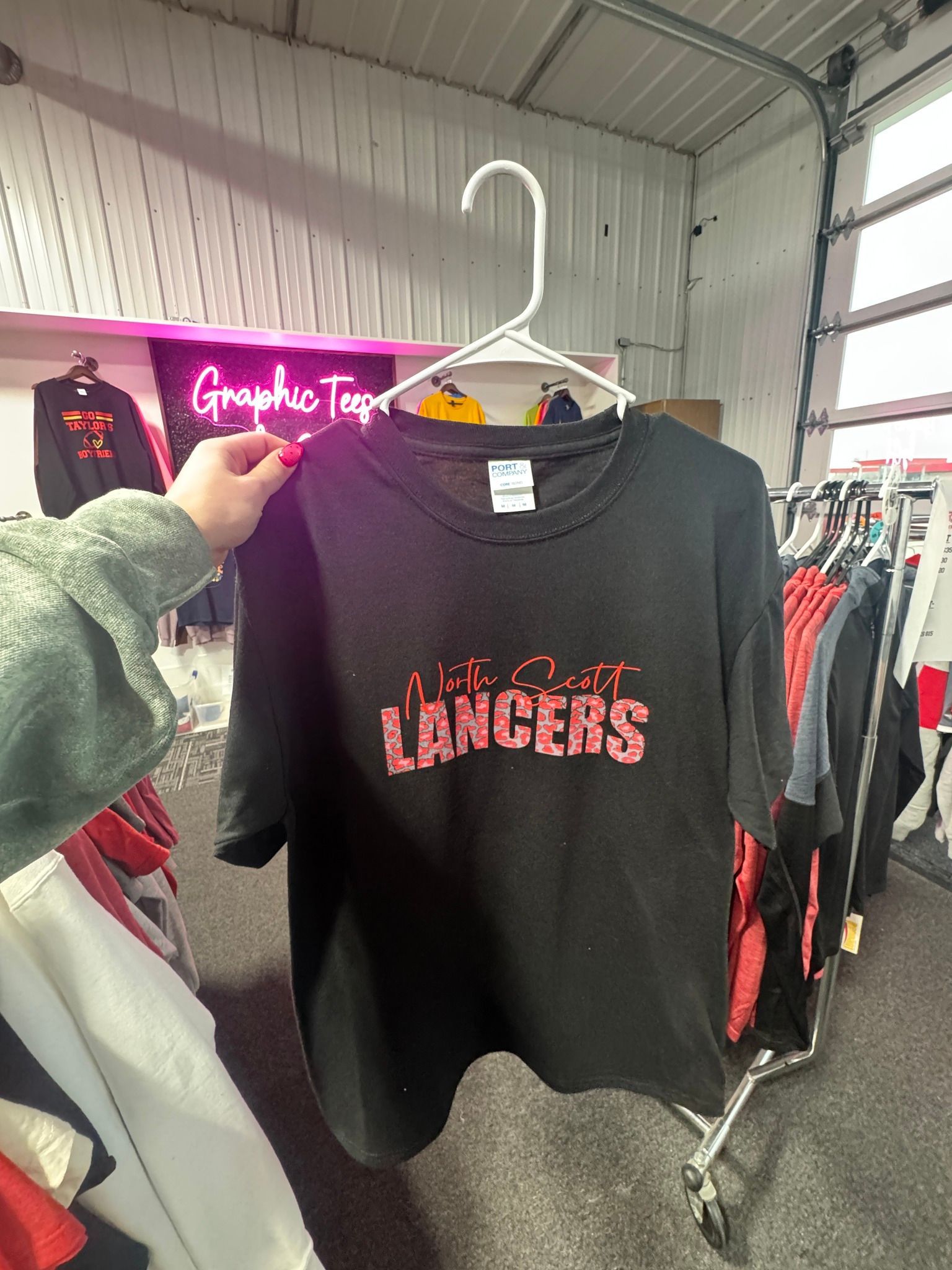 A person is holding a black t-shirt with the word lancers on it.