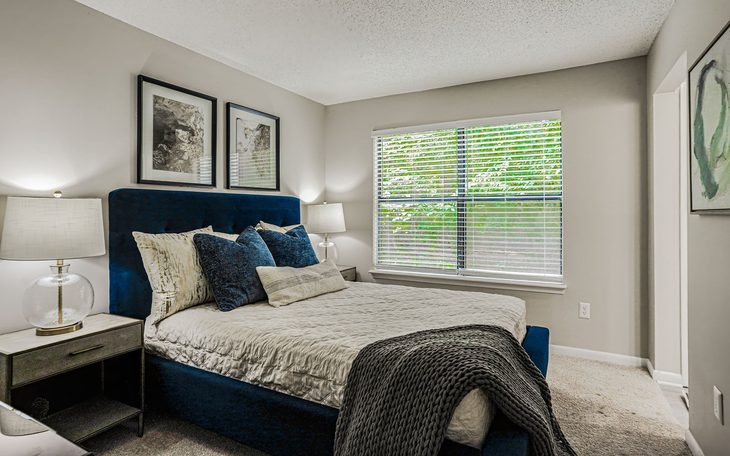 Swimming pool with lounge chairs, tables, and a clubhouse in the background.