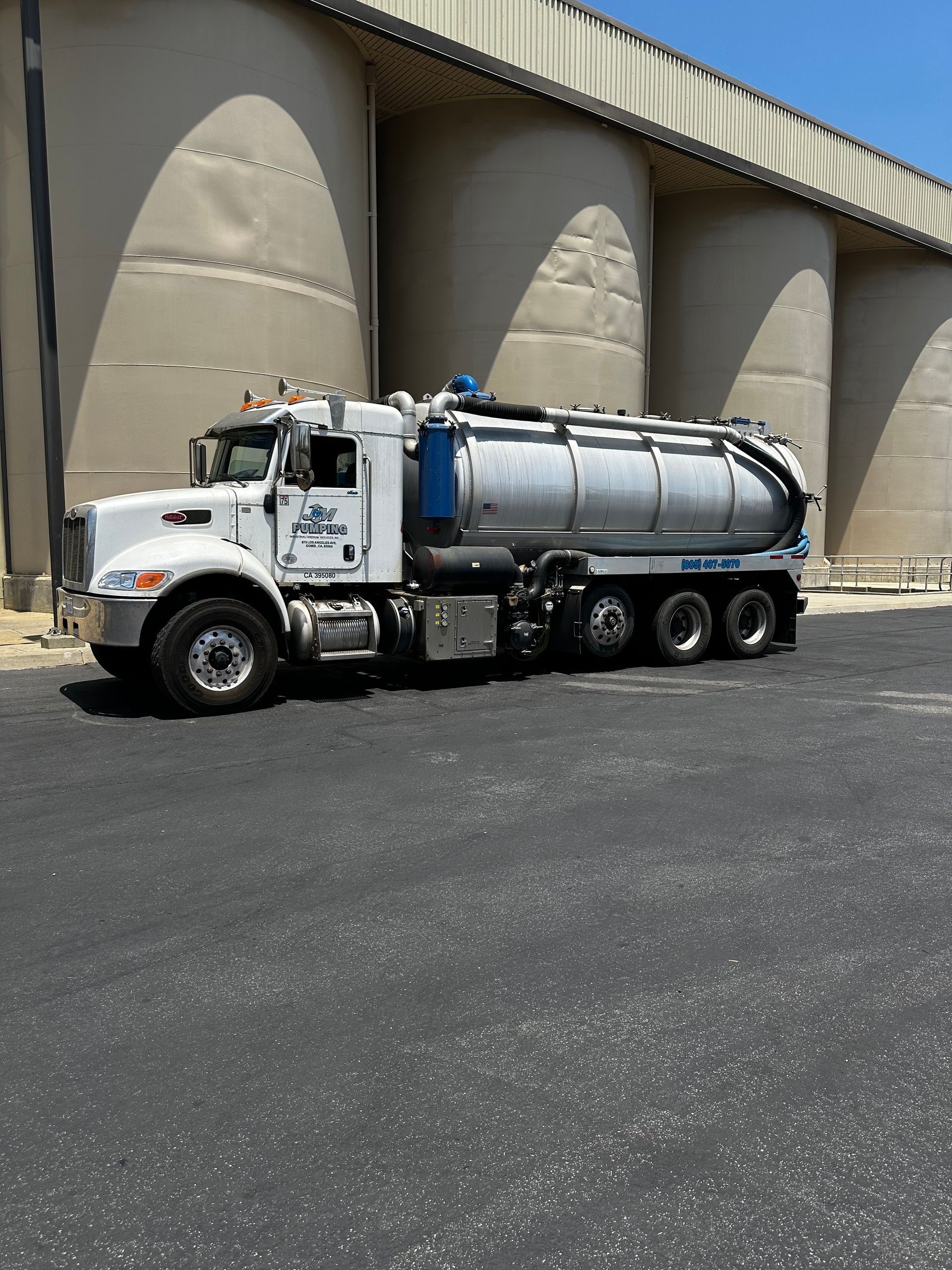 A vacuum truck is parked in front of a building
