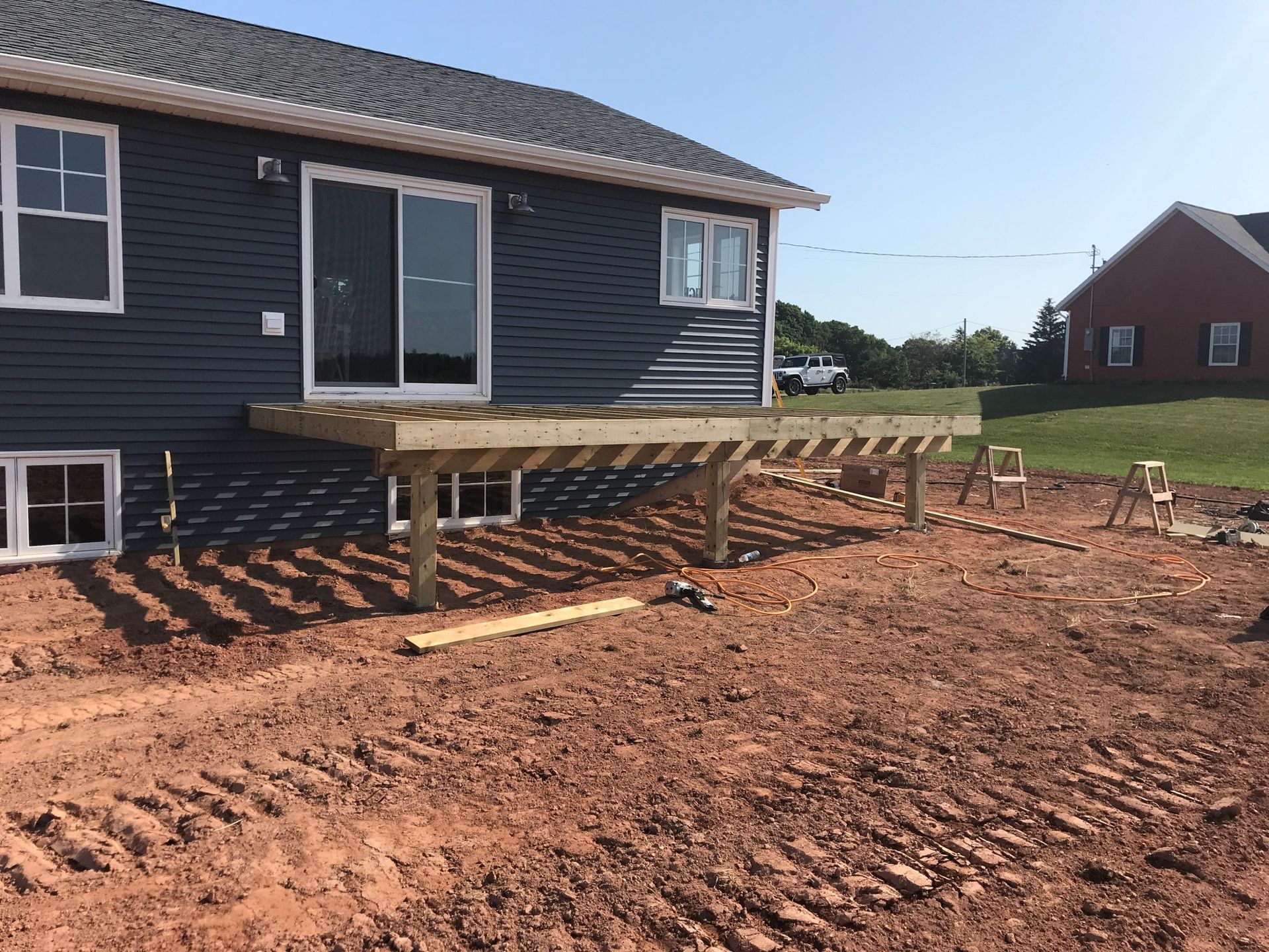 A wooden deck is being built in front of a house.