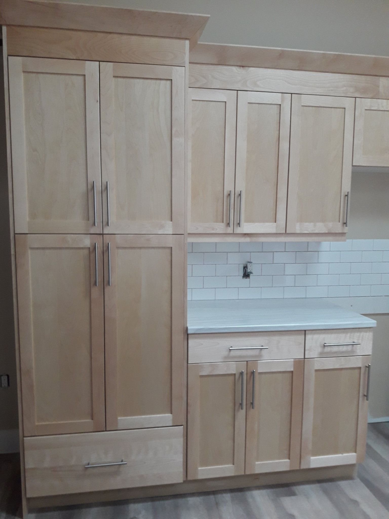 A kitchen with wooden cabinets and a white counter top