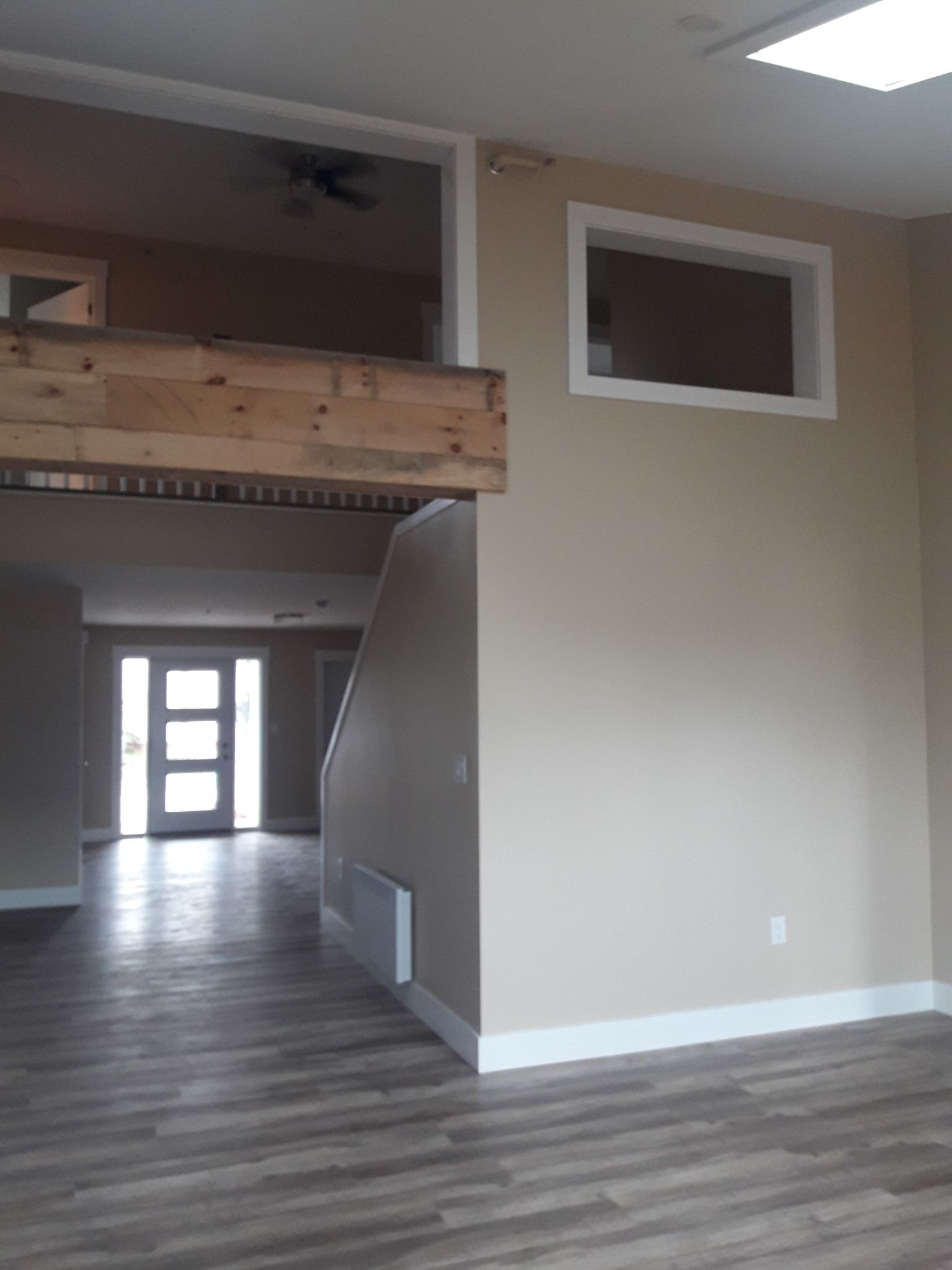An empty room with a staircase and a ceiling fan