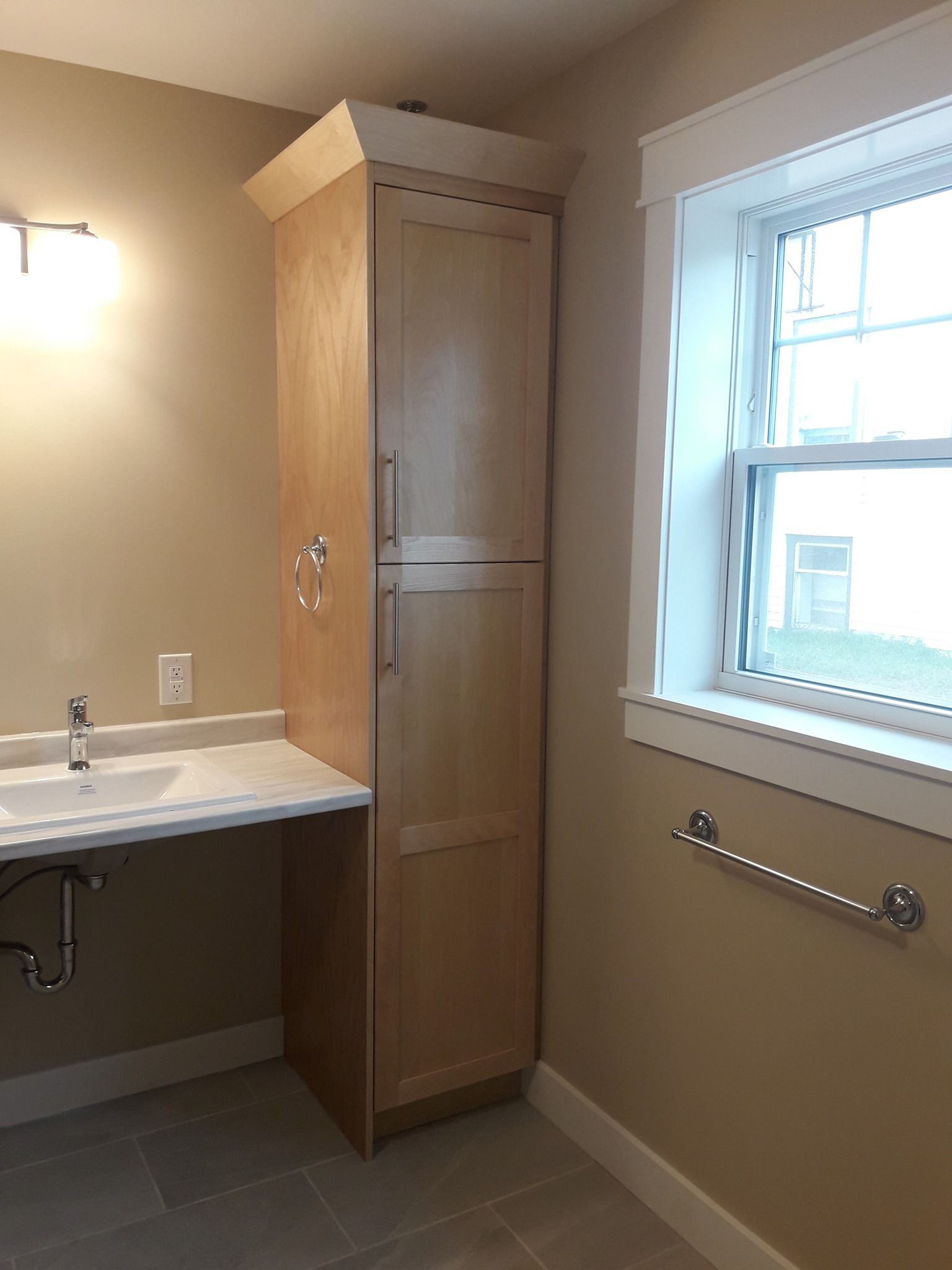 A bathroom with a sink a cabinet and a window
