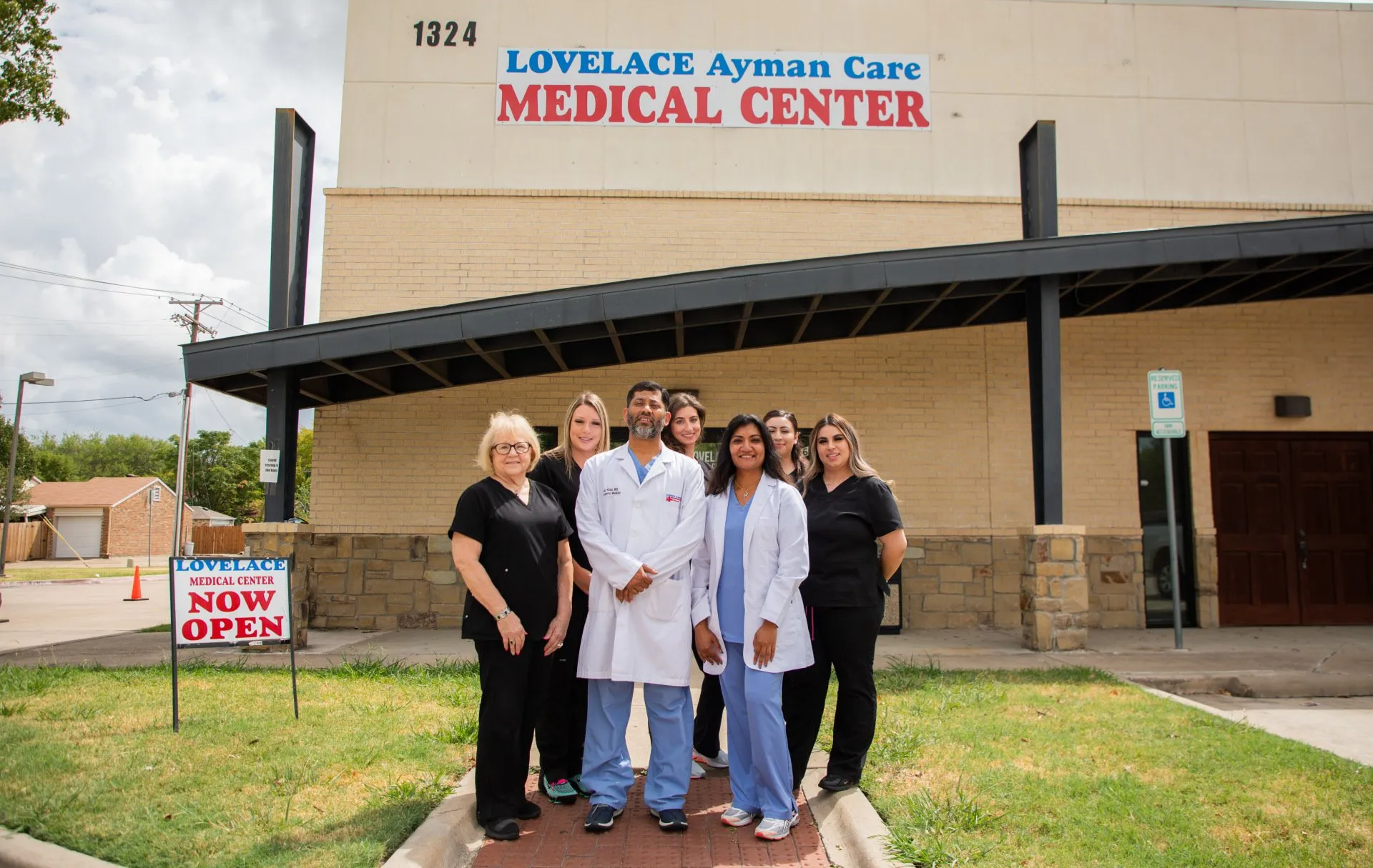 a group of people standing in front of a medical center
