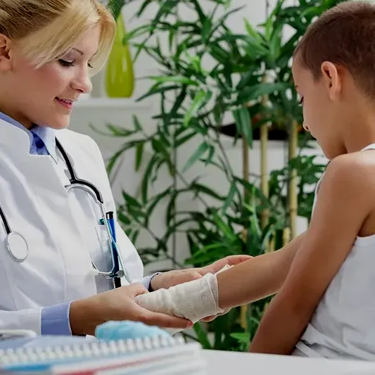 a doctor is talking to a young boy with a bandaged arm