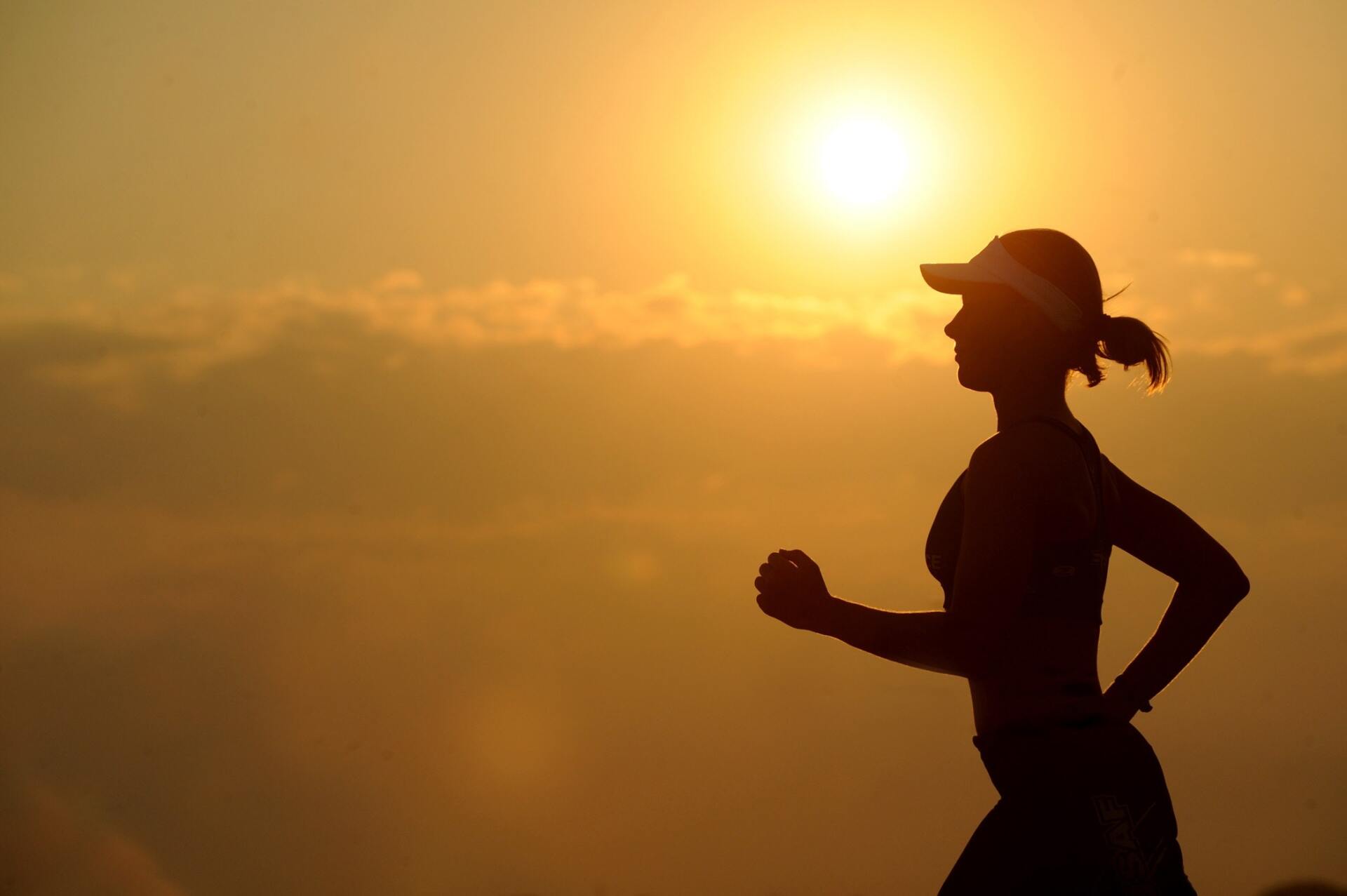 A silhouette of a woman running at sunset