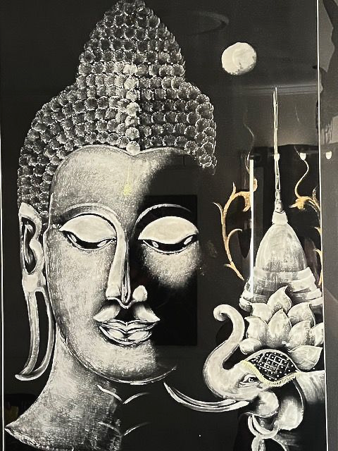 Buddha's face, half in light, with a stupa and moon in a black background.