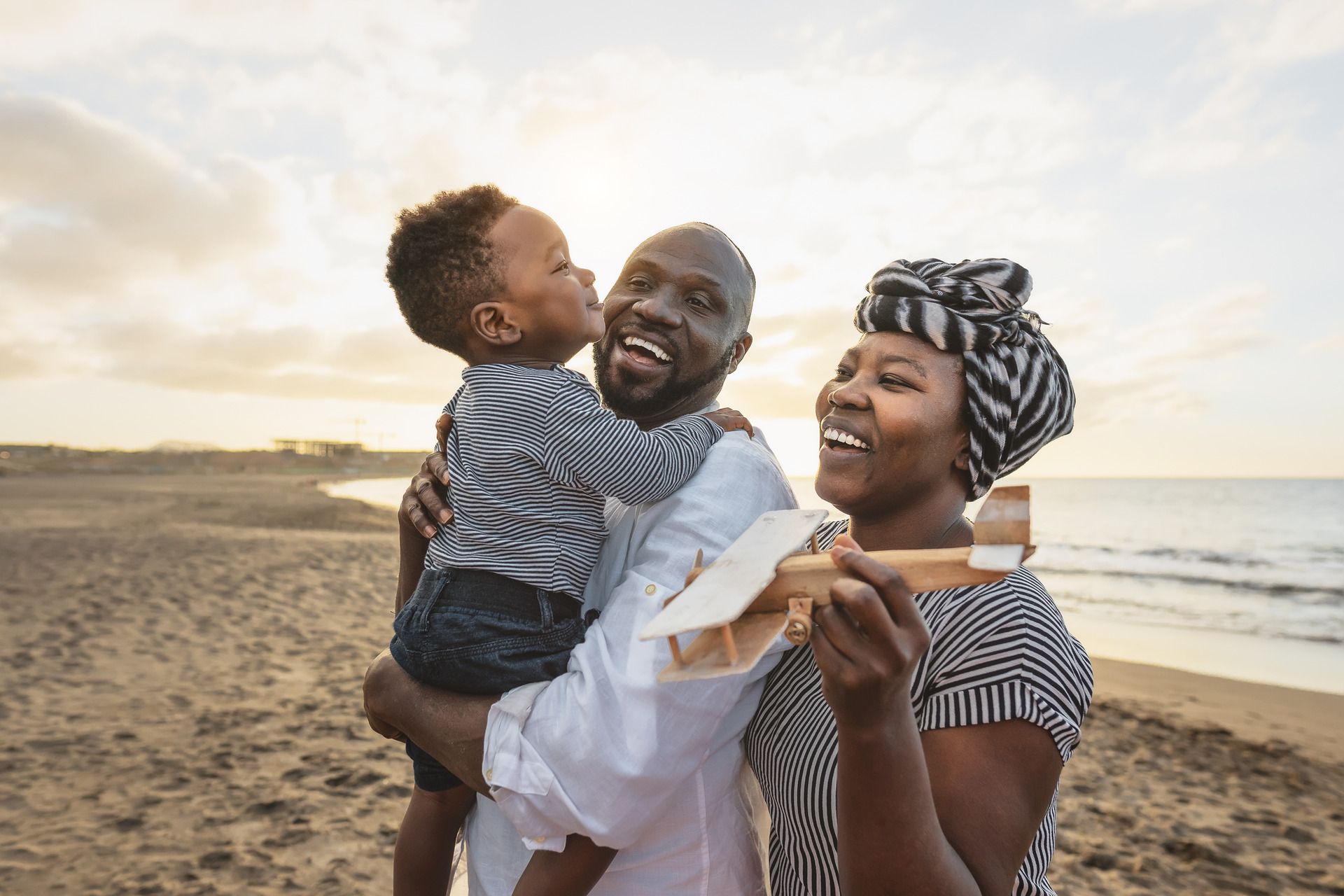 Family of 3 with child on fathers shoulders, happy together