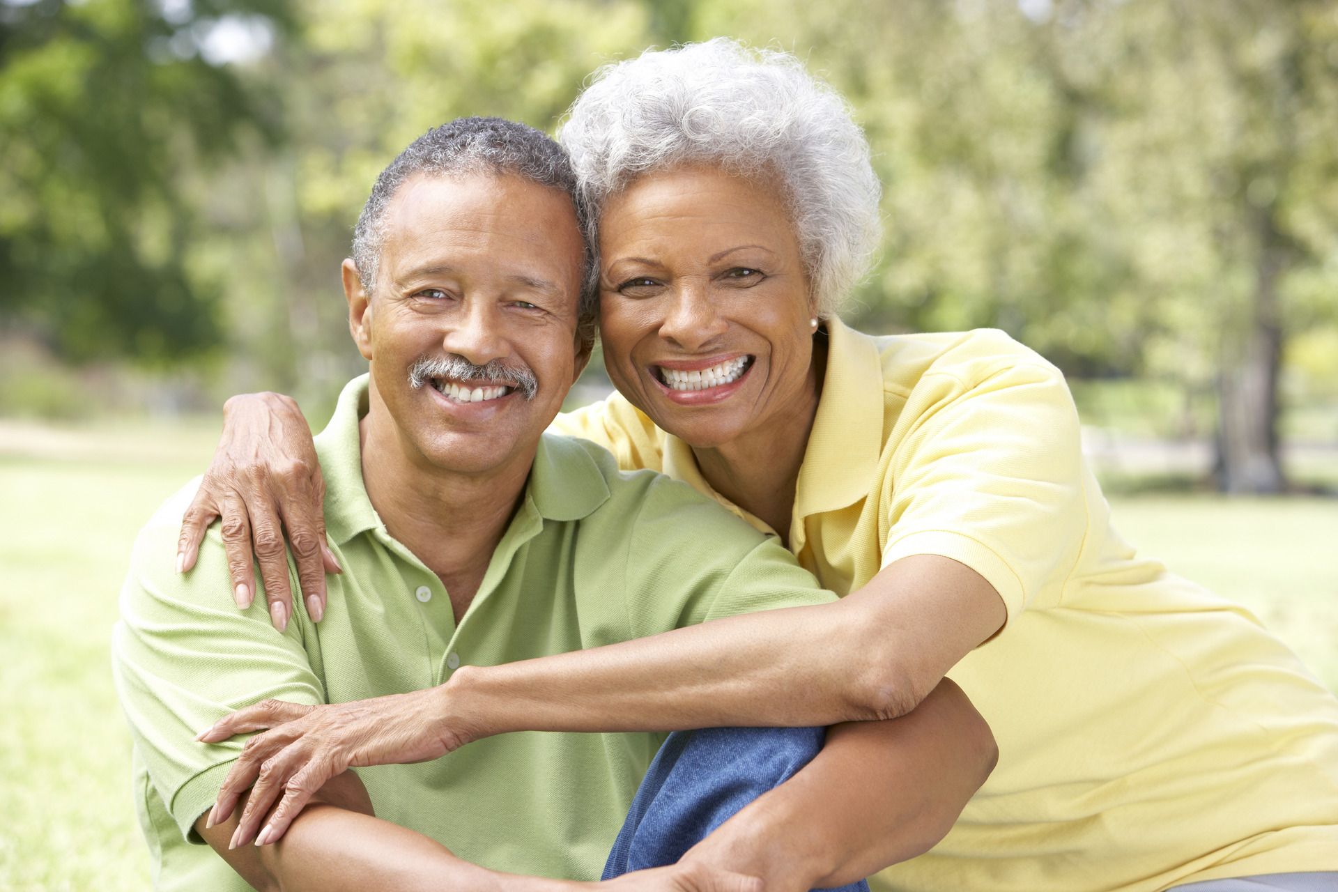 White elderly couple embracing each other at the park