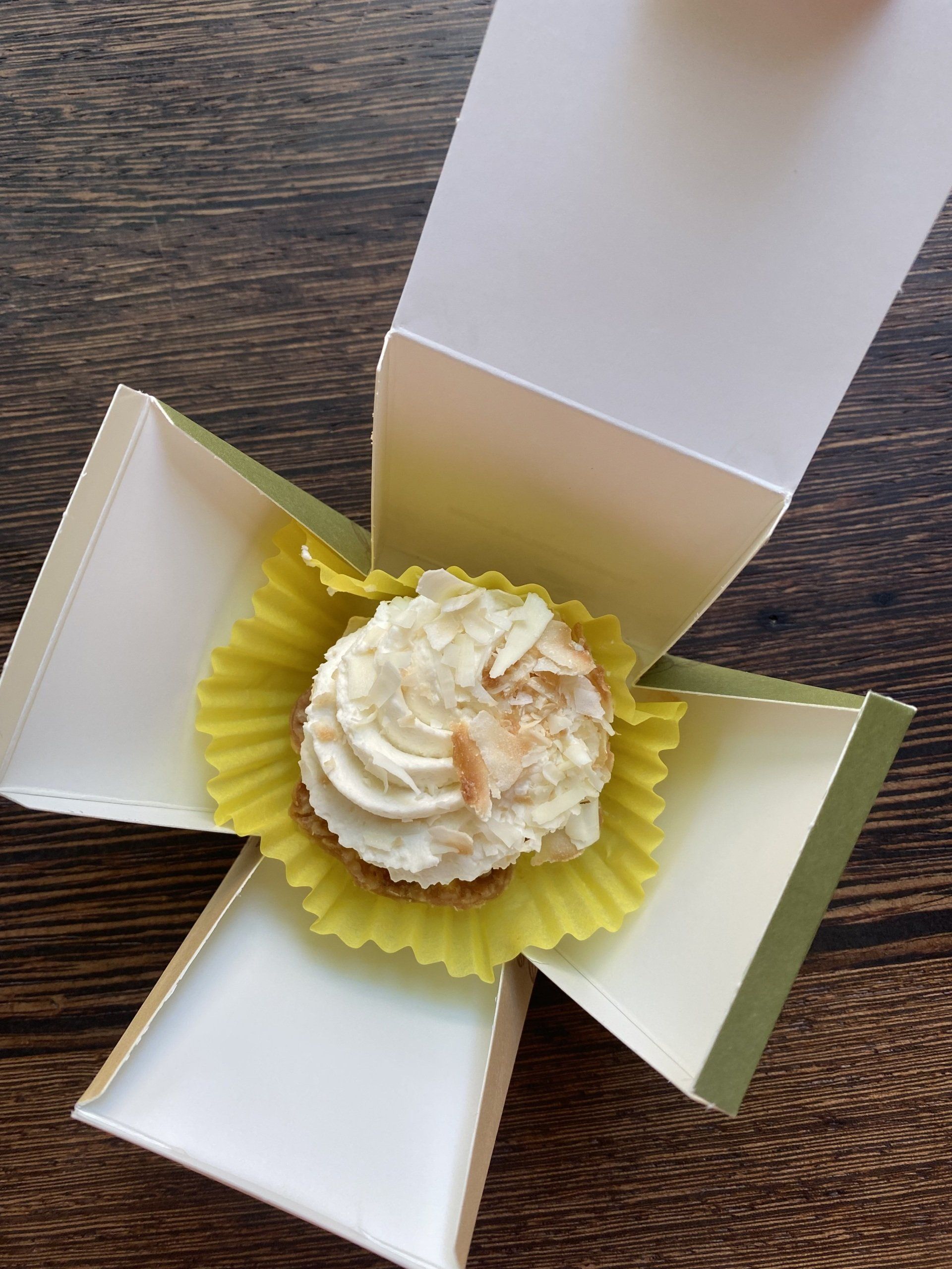 A close up of a cupcake in a box on a table.