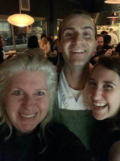 A man and two women are posing for a picture in a restaurant.