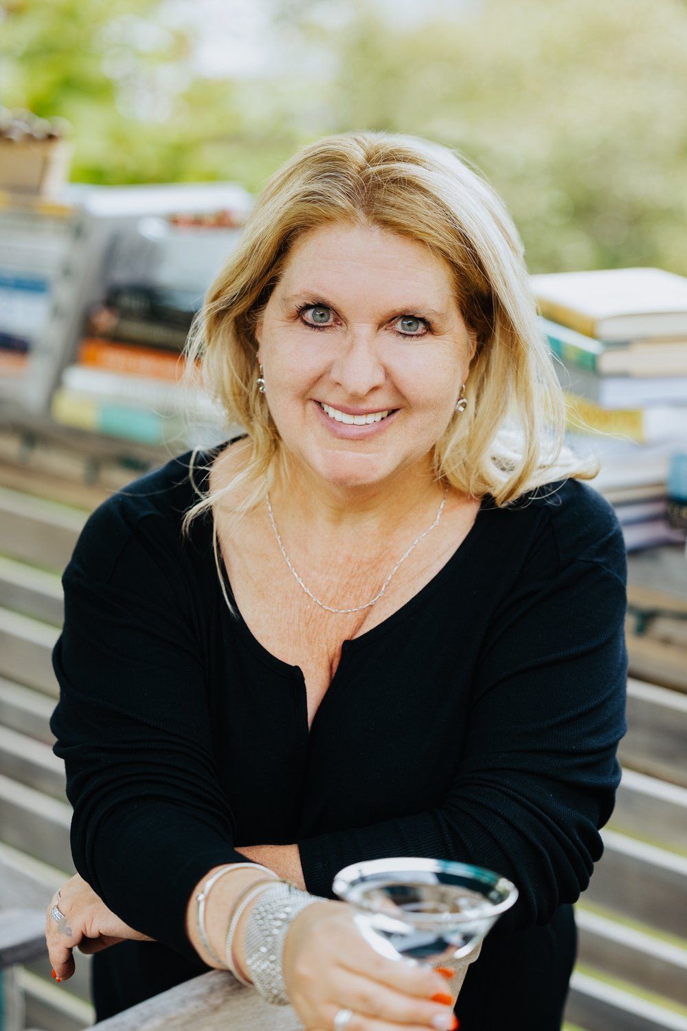 A woman is sitting on a bench holding a martini glass.