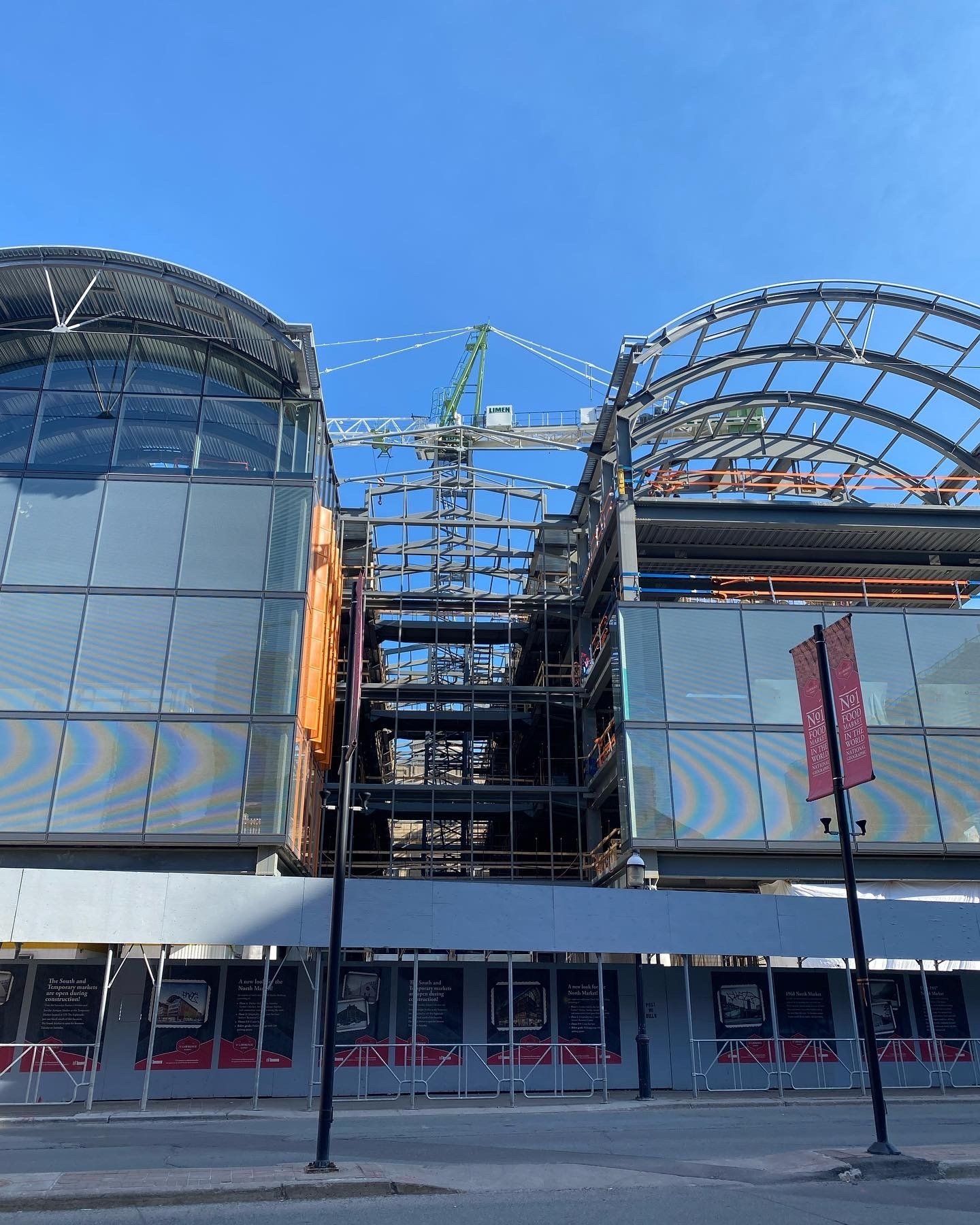 A large building under construction with a crane in the background.
