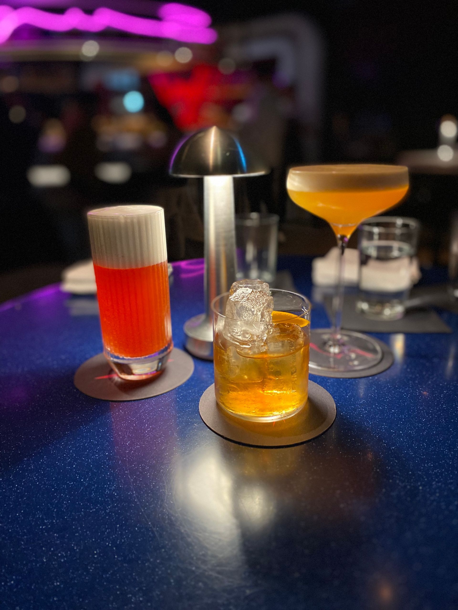Three drinks are sitting on a blue table