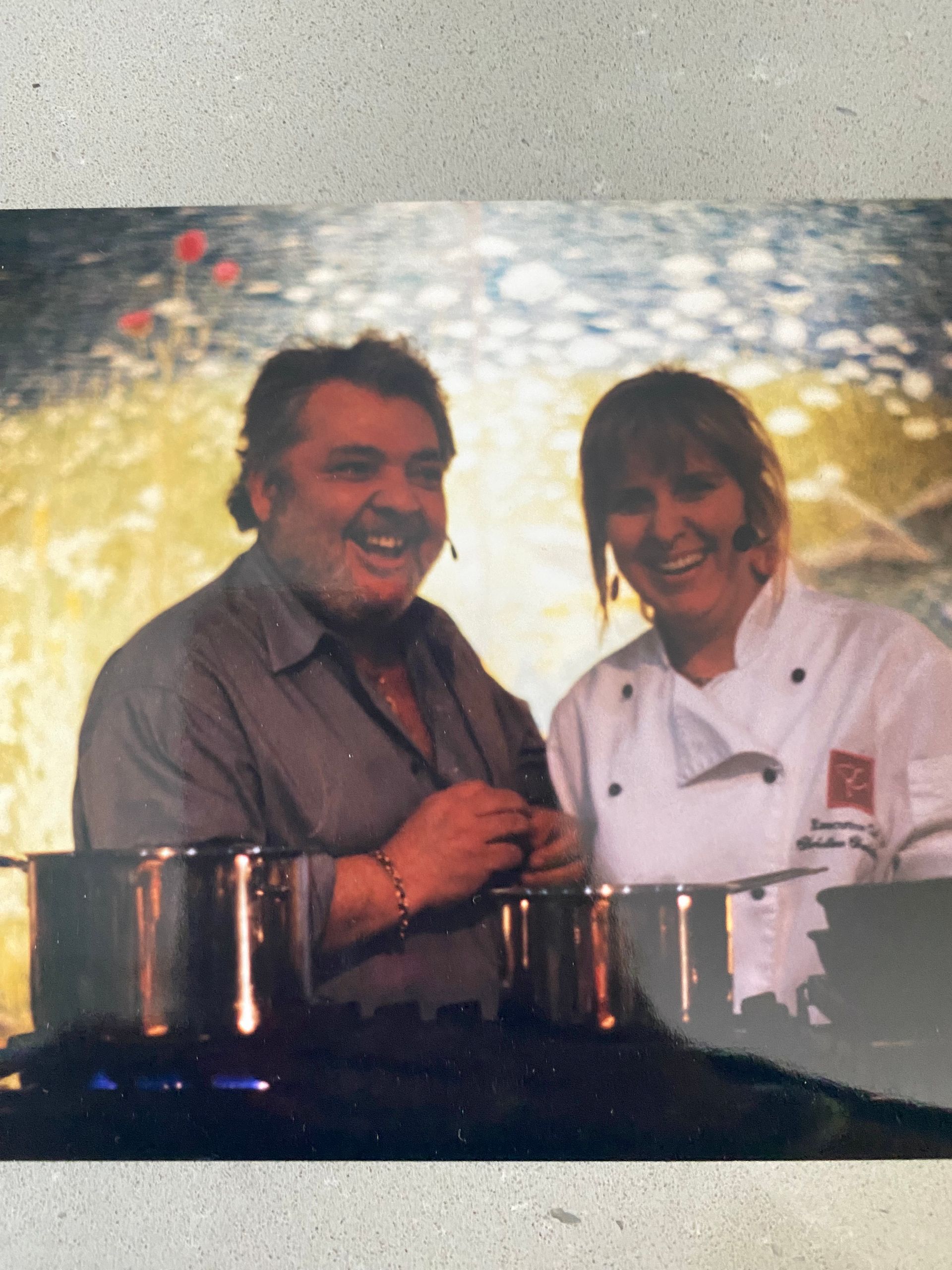 A man and a woman are standing next to pots and pans
