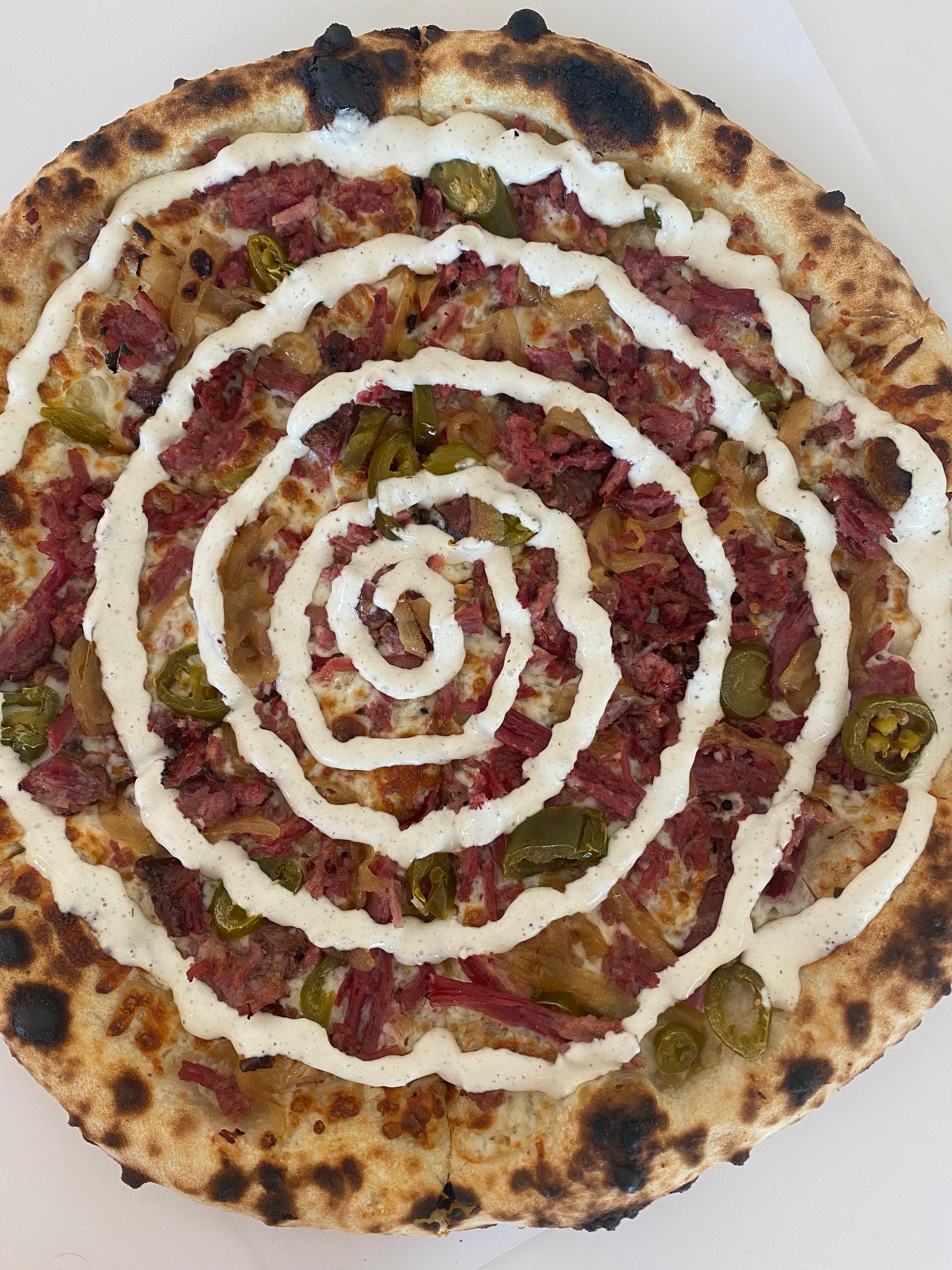 A pizza with a swirl of sauce on it