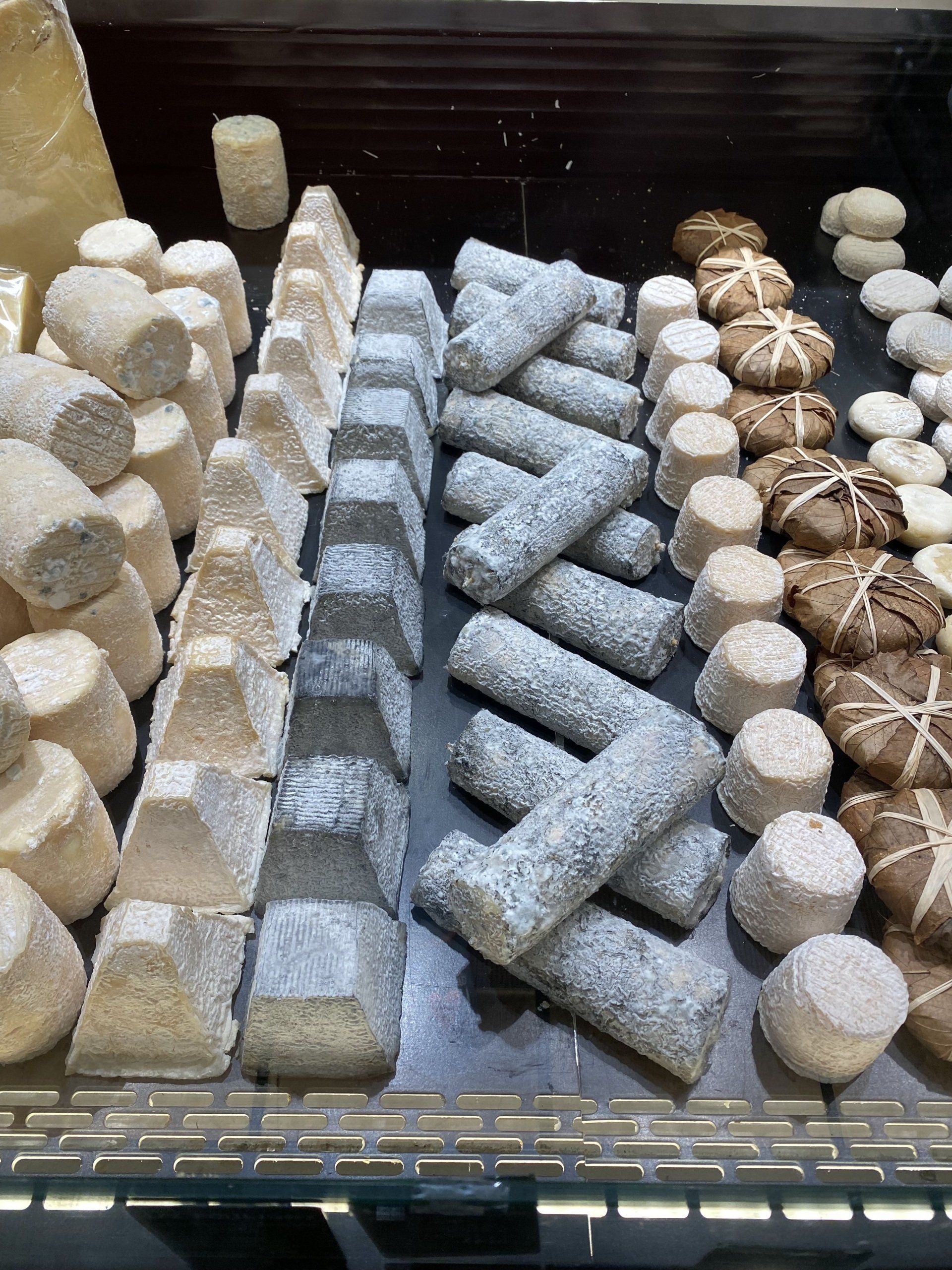 A variety of cheeses are sitting on a table.