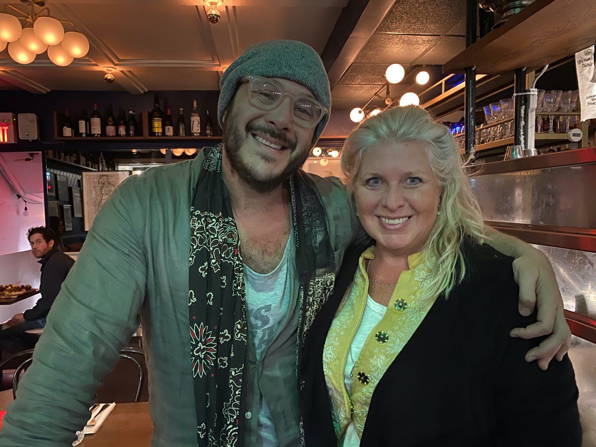 A man and a woman are posing for a picture in a restaurant.
