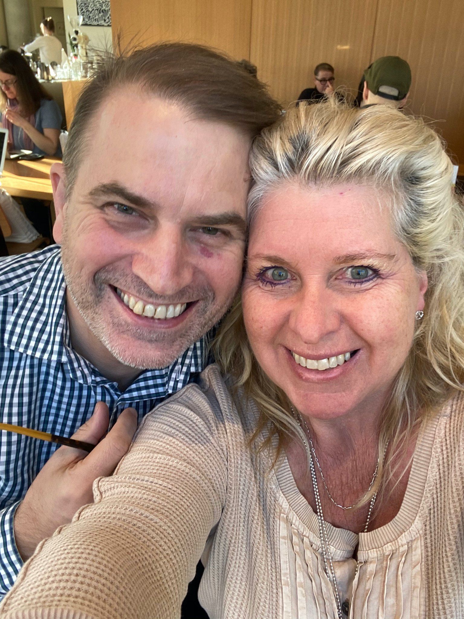 A man and a woman are posing for a selfie in a restaurant.
