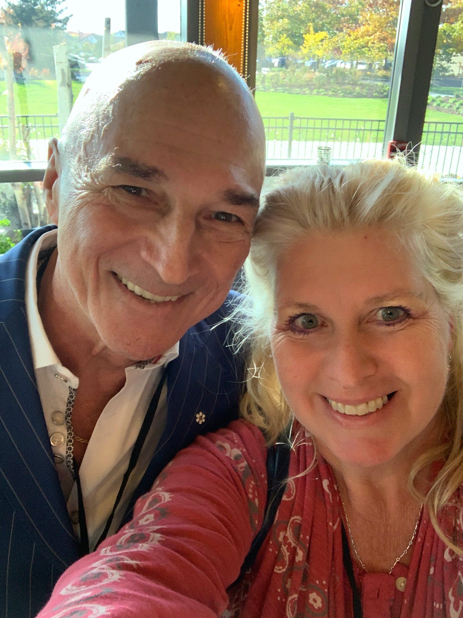 A man and a woman are posing for a selfie and smiling for the camera.
