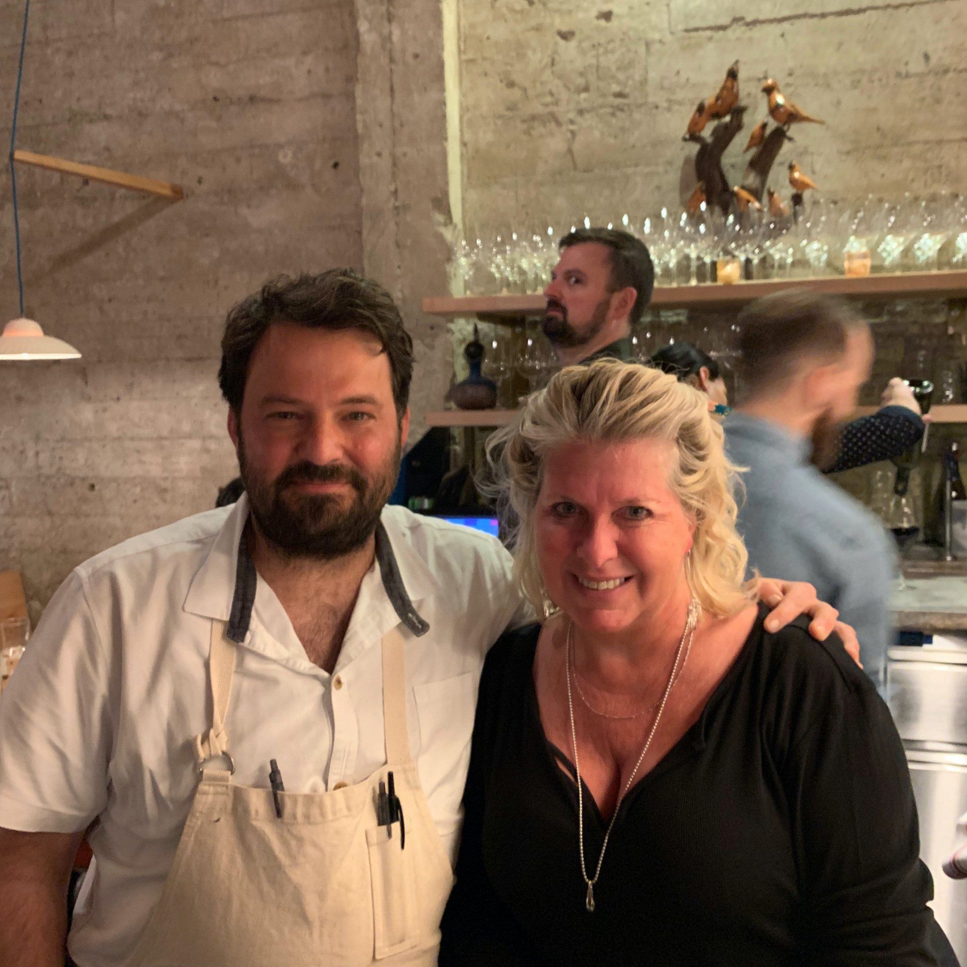 A man and a woman are posing for a picture in a restaurant