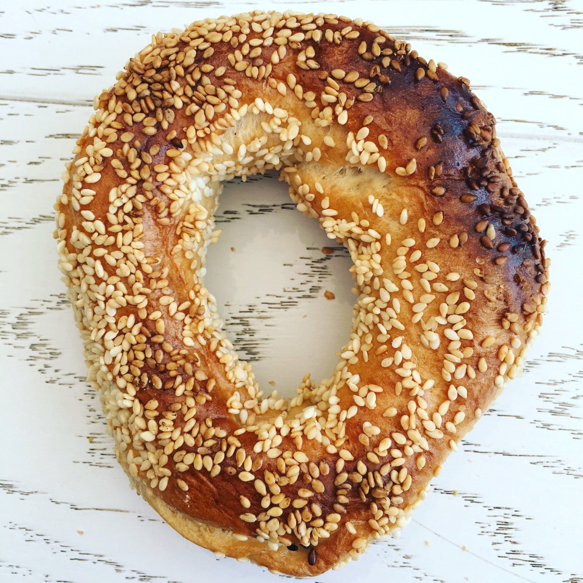 A close up of a sesame seed bagel on a table