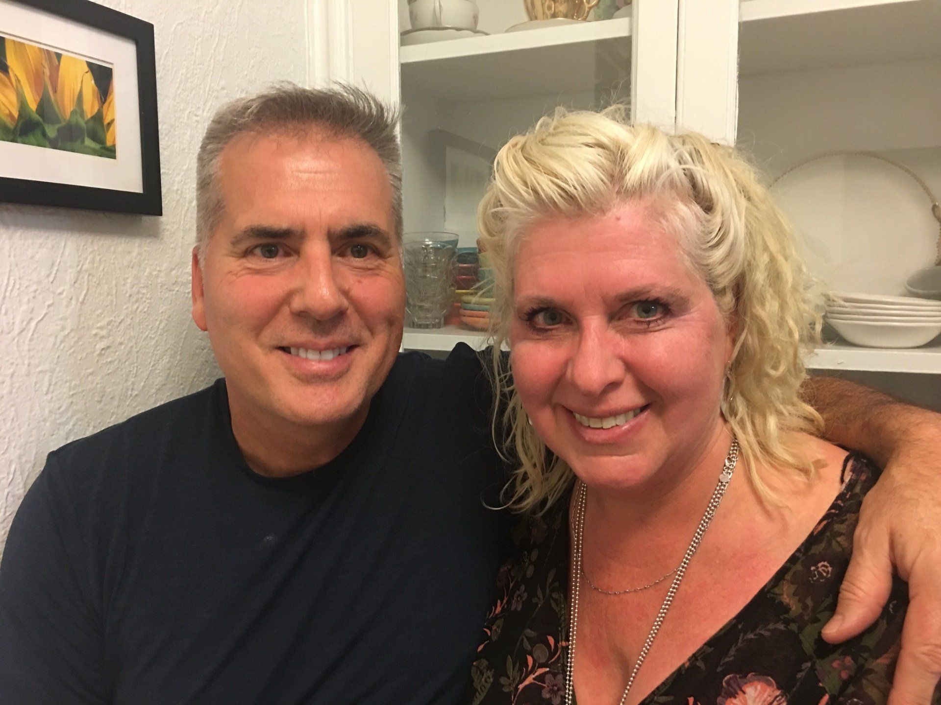 A man and a woman are posing for a picture in a kitchen.