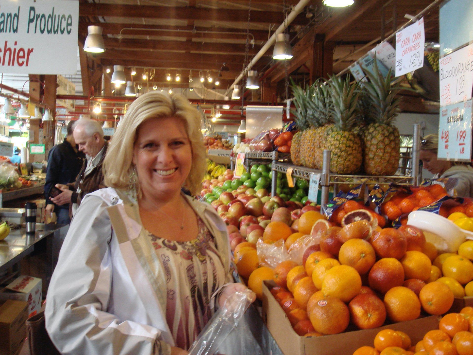 A woman is standing in front of a sign that says produce