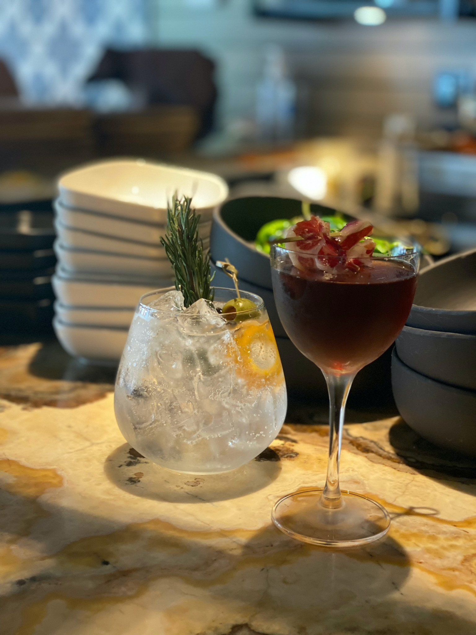 A glass of wine is sitting on a table next to a glass of ice.
