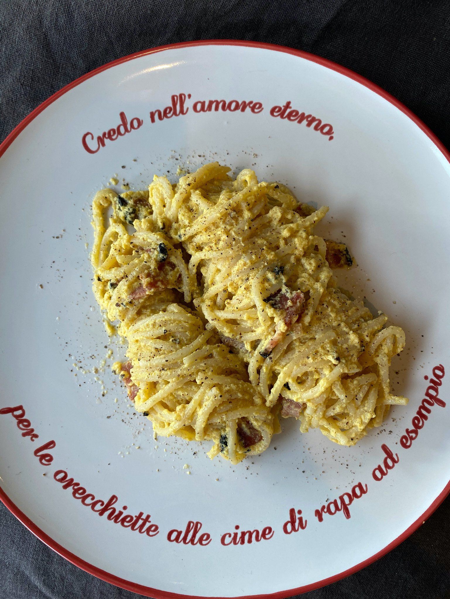 A white plate with spaghetti on it that says credo nell ' amore demo