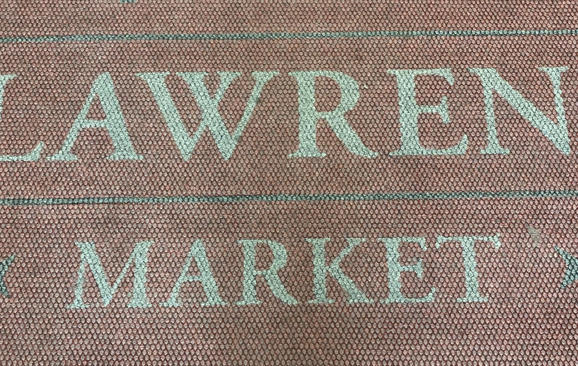 A brick wall with the words lawren market written on it.