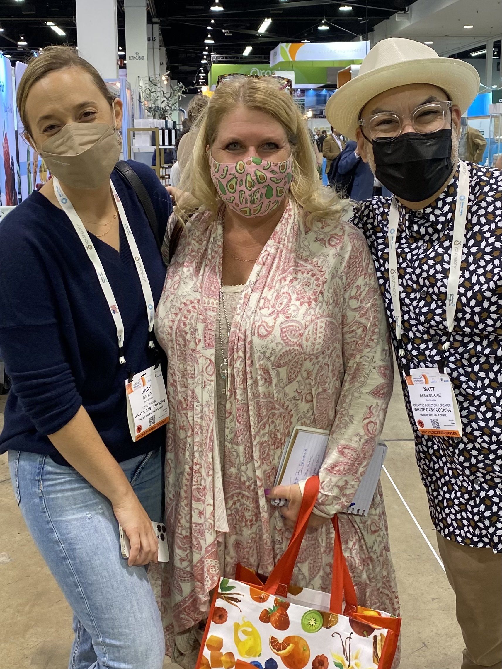 Three people wearing face masks are posing for a picture.