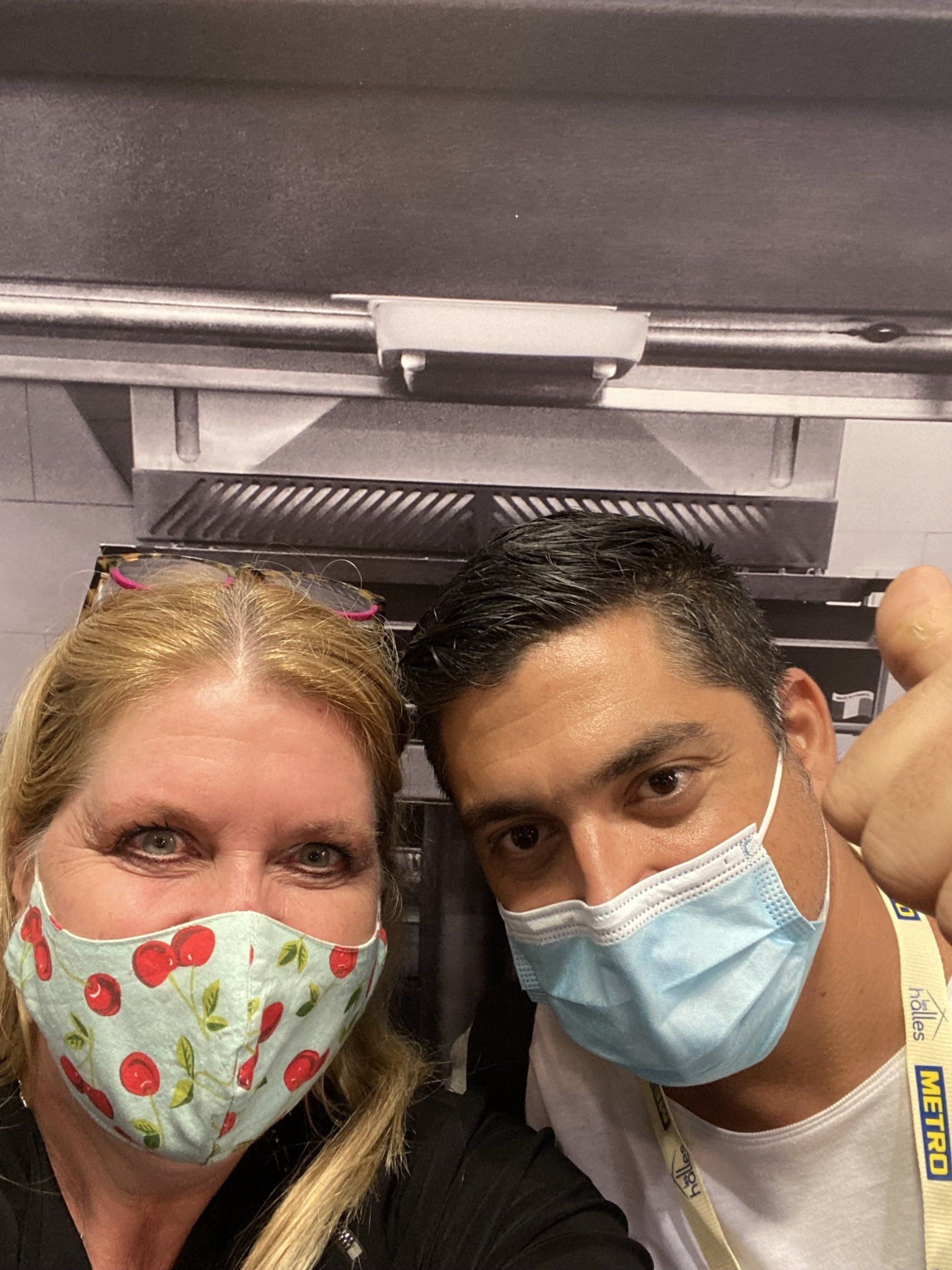 A man and a woman wearing face masks are posing for a picture.