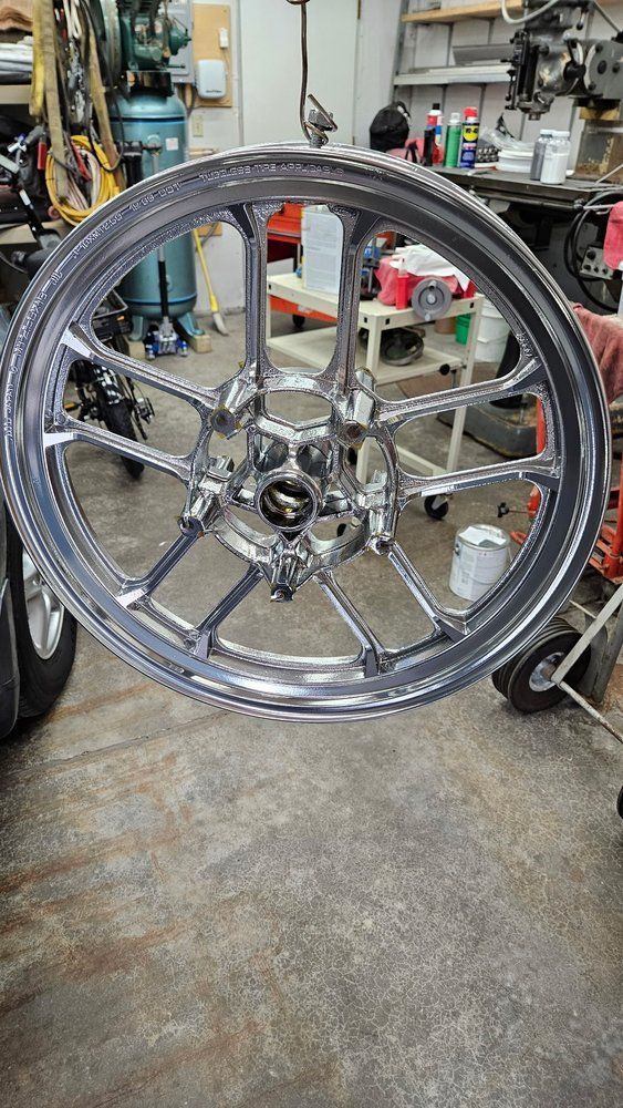 Shiny chrome motorcycle wheel with multiple spokes.