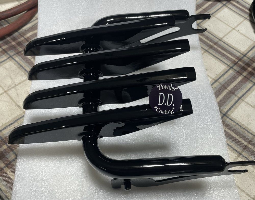 Black motorcycle fender with multiple horizontal bars, resting on white foam.