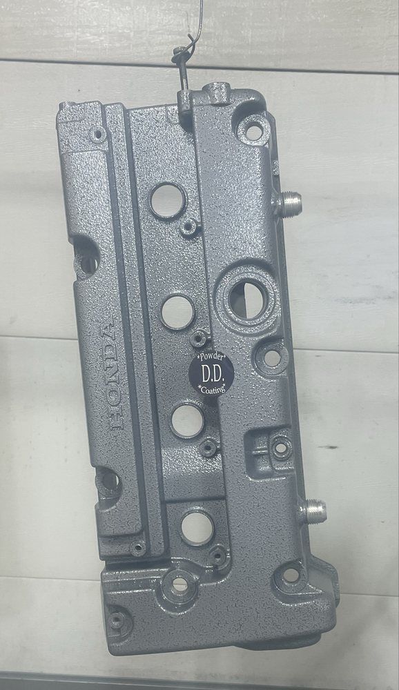 Gray, textured engine part with various holes, labeled 