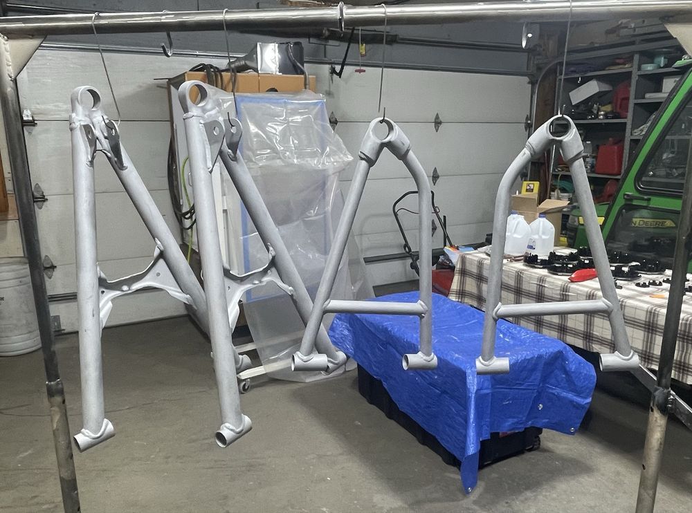 Silver painted metal frames hanging inside a garage.