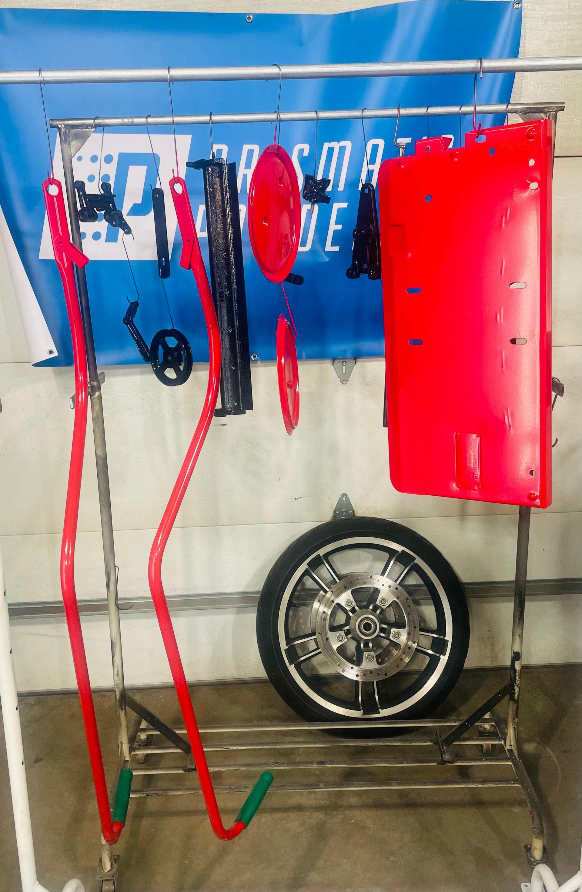 Two motorcycle wheels, one old and dusty, the other newly polished and shiny, displayed in comparison.