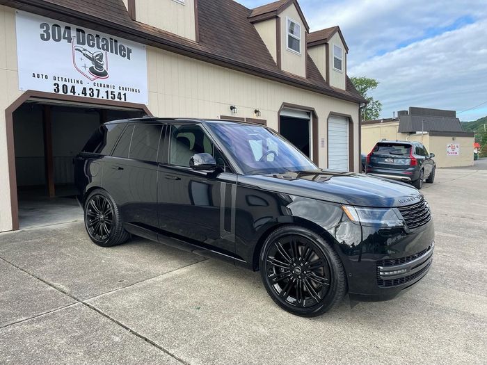 A black range rover is parked in front of a car wash.