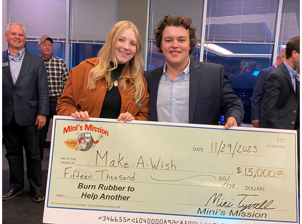 A man and a woman are holding a large check.