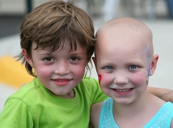 A boy and a girl are posing for a picture together.