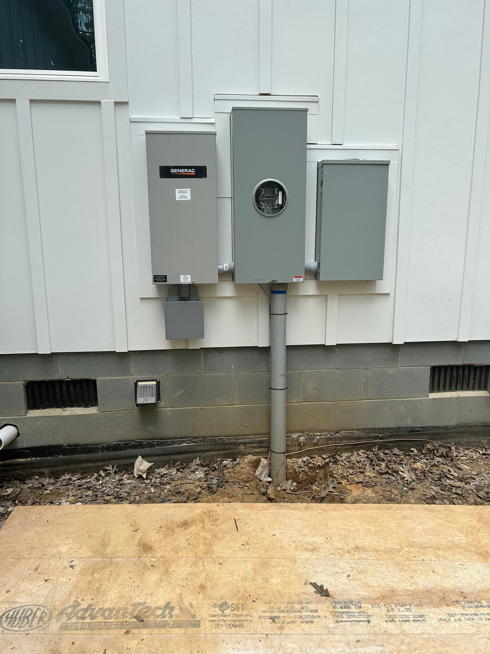 Electrical meter boxes mounted on a white building's exterior.