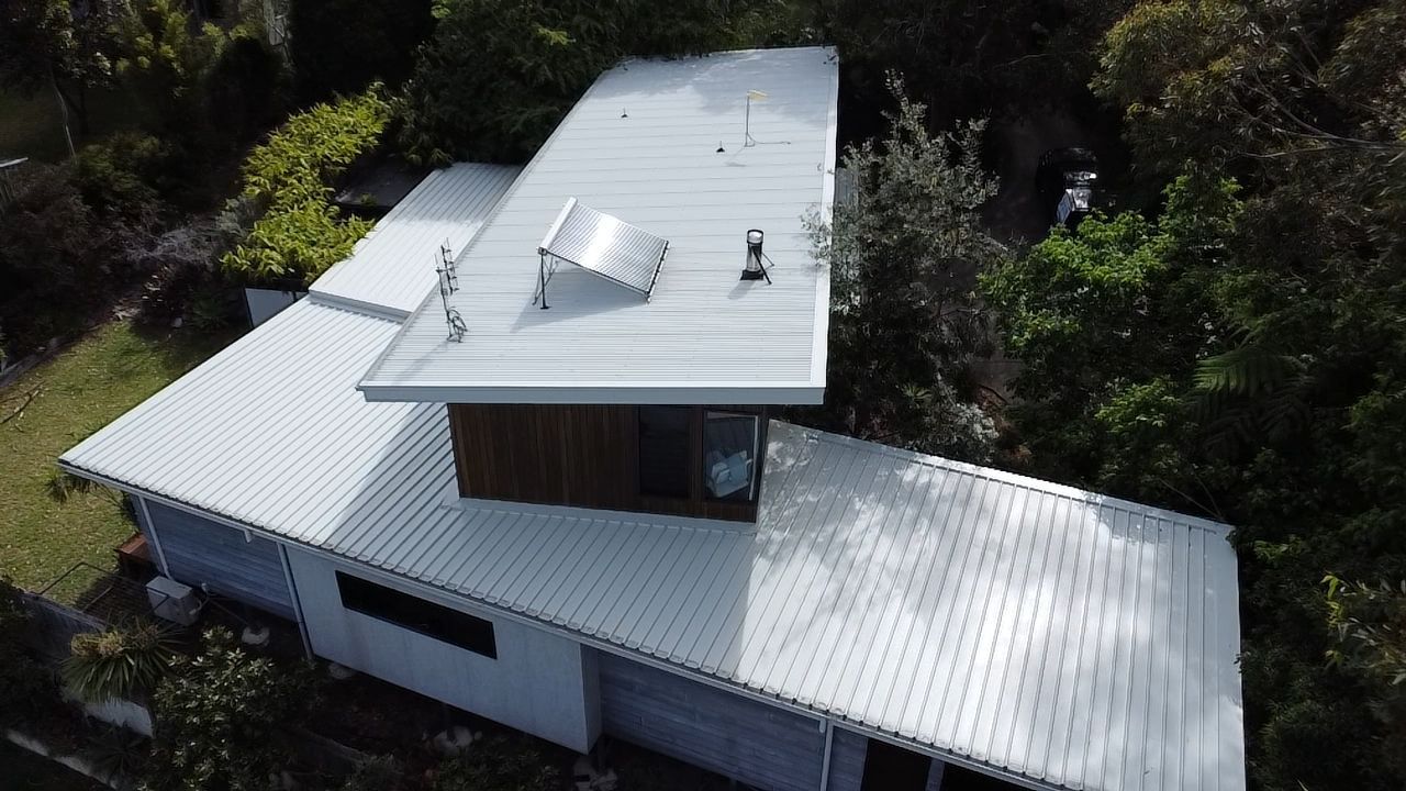 A Person Is Using A Pressure Washer To Clean A Building — Jervis Bay Pressure Washing & Property Maintenance In Bowral, NSW