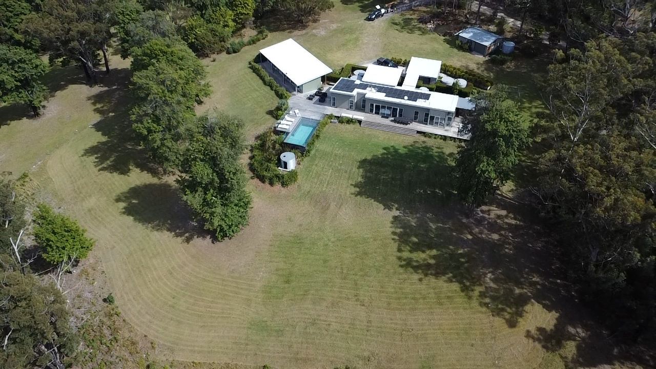 A Person Is Cleaning A Window With A Brush — Jervis Bay Pressure Washing & Property Maintenance In Sussex Inlet, NSW