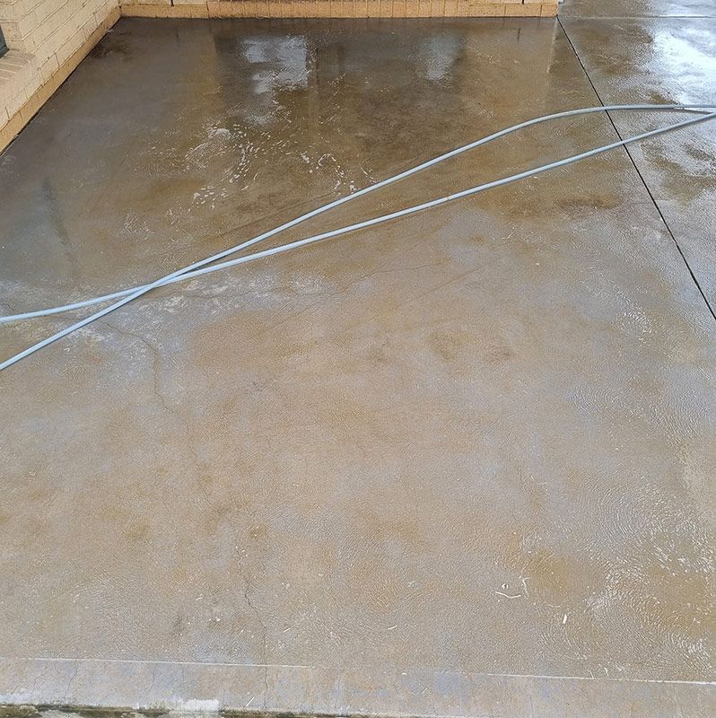 A Concrete Floor With A Hose During Cleaning — Jervis Bay Pressure Washing & Property Maintenance in Vincentia, NSW