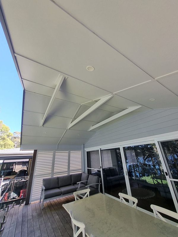 A Wooden Deck Patio With A Table And Chairs — Jervis Bay Pressure Washing & Property Maintenance in Sanctuary Point, NSW