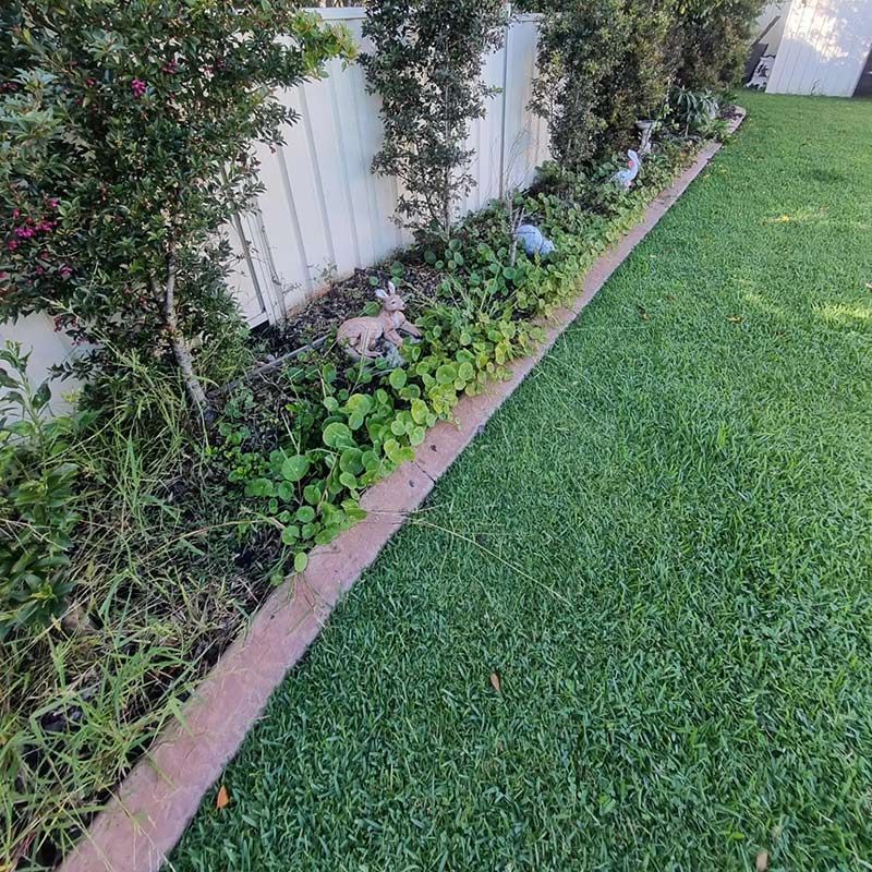 A Lush Green Yard With A White Fence — Jervis Bay Pressure Washing & Property Maintenance In Sanctuary Point, NSW