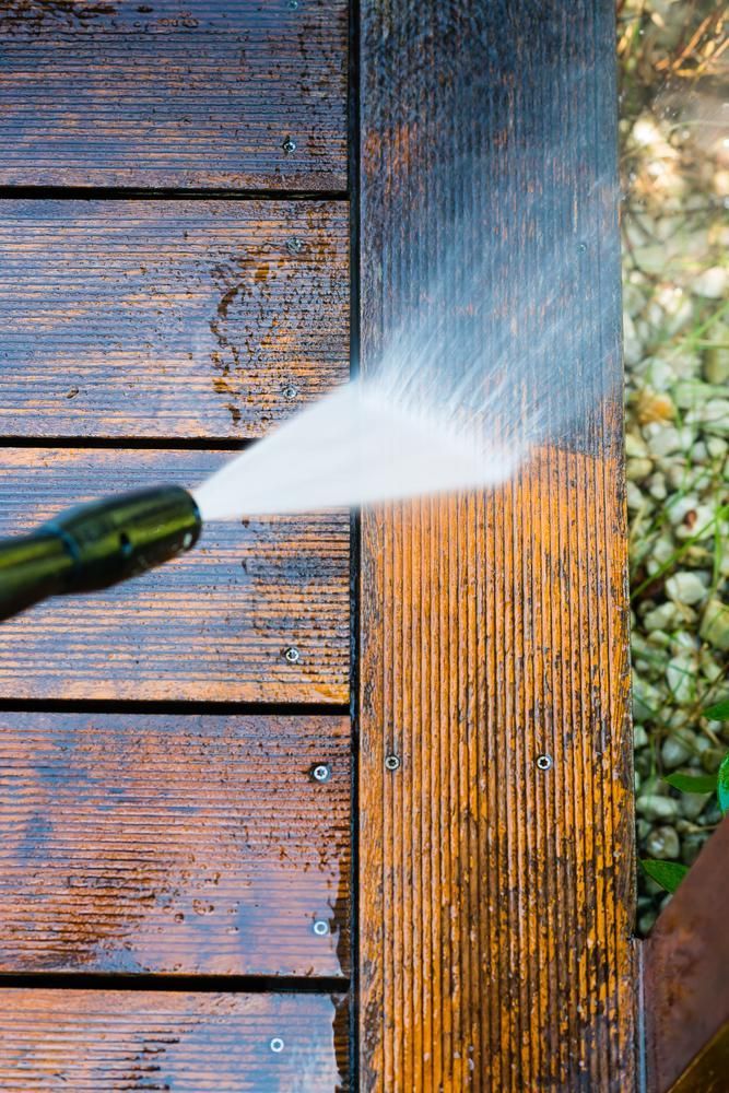 Person Is Using Pressure Washer To Clean A Wooden Deck — Jervis Bay Pressure Washing & Property Maintenance In Nowra, NSW