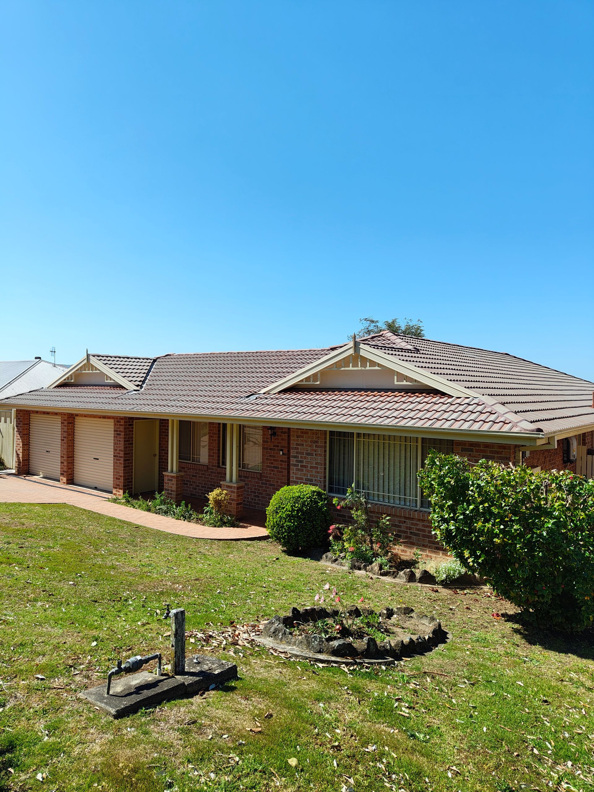 A Brick House With A Cleaned Tiled Roof — Jervis Bay Pressure Washing & Property Maintenance in Sanctuary Point, NSW