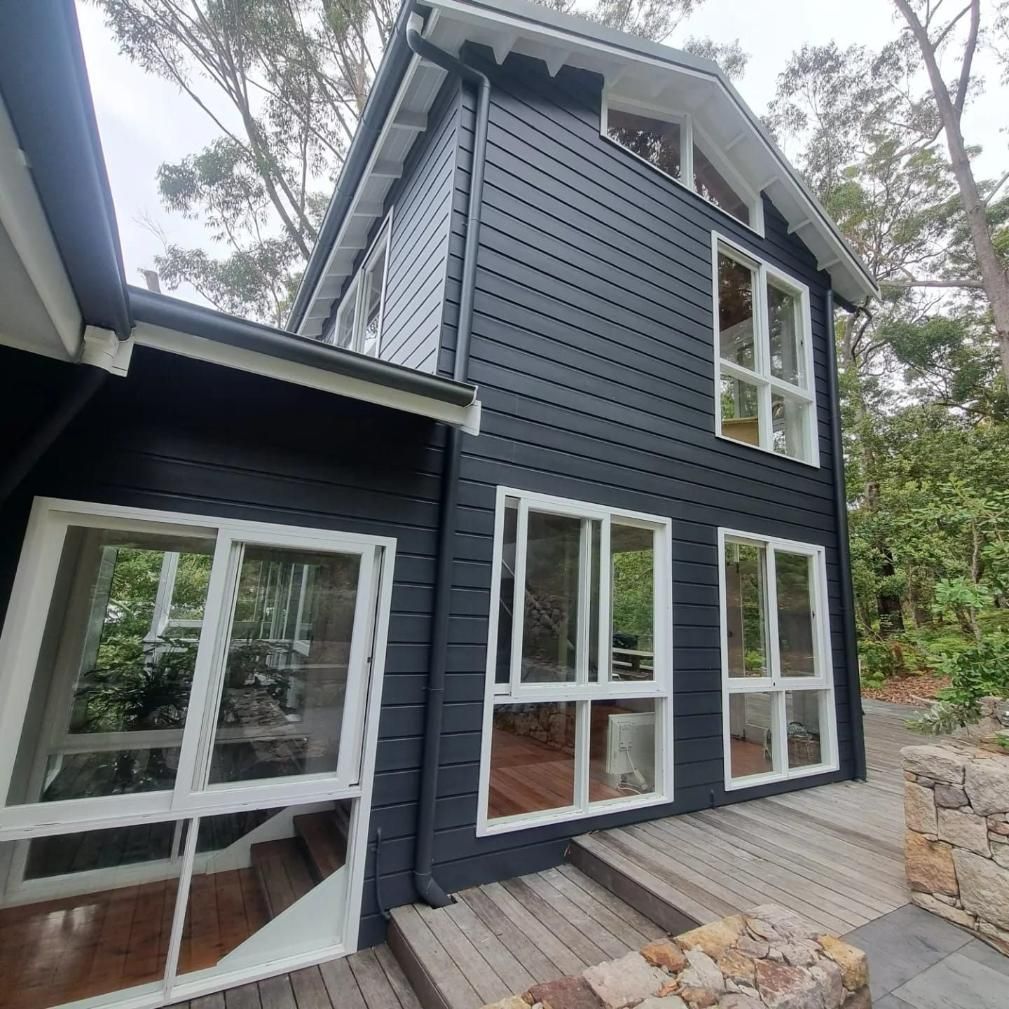 A Black House With A Lot Of Windows And Stairs — Jervis Bay Pressure Washing & Property Maintenance in Sanctuary Point, NSW